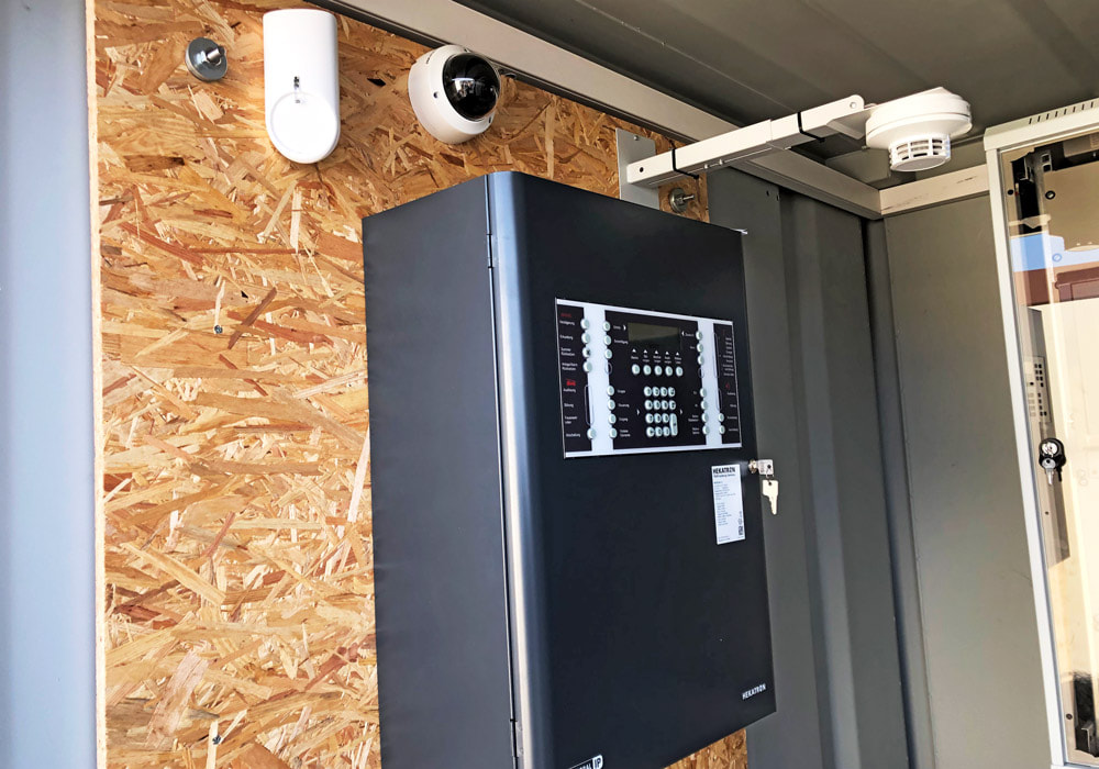 Neubau Sicherheitstechnik auf Solarpark: Installation einer Brandmeldezentrale, eines Rauchmelders, von PIR und Kameras