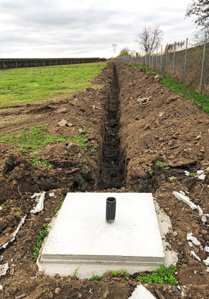 Neubau Sicherheitstechnik auf Solarpark: Errichtung eines Kabelgrabens mit Sandbett