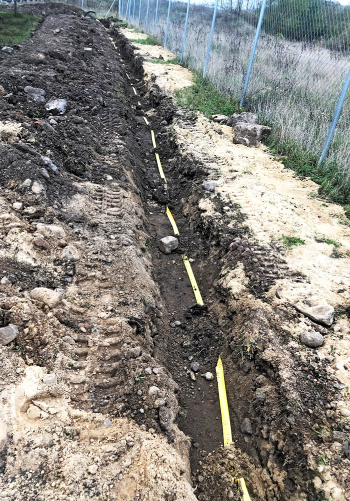 New construction of safety technology on a solar park: construction of a cable trench with fiber optic and power cables