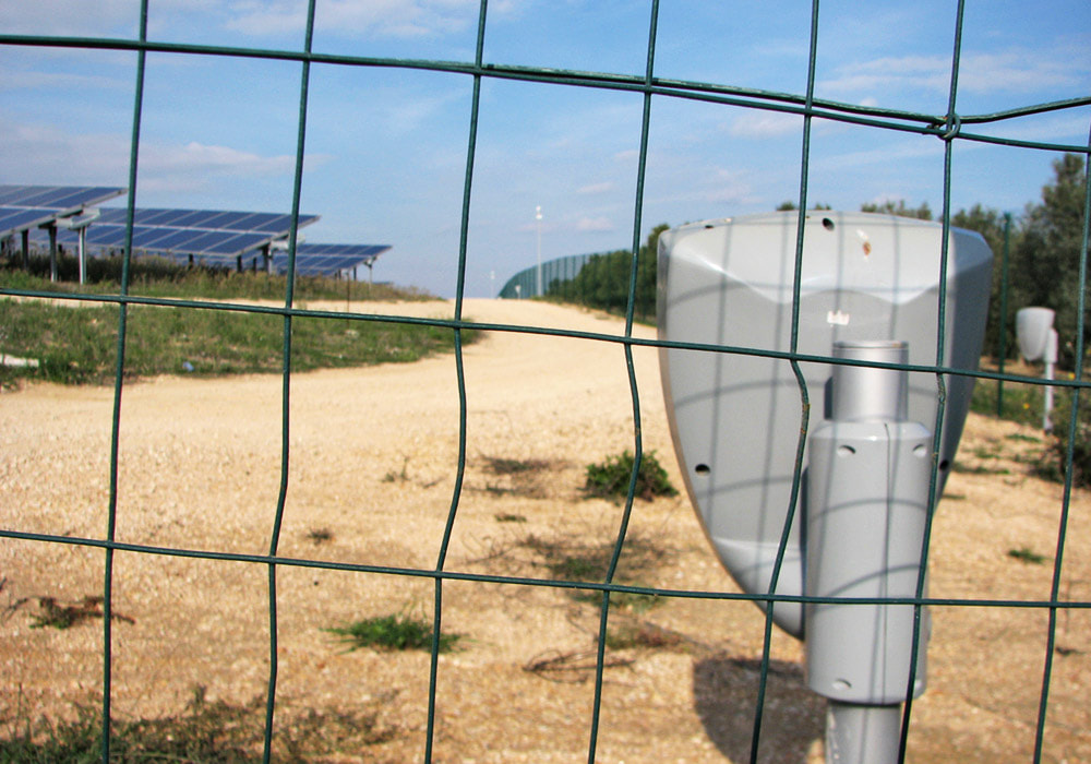 Nachrüstung Sicherheitstechnik auf Solarpark: Anbringung eines Mikrowellenmelders am Zaun