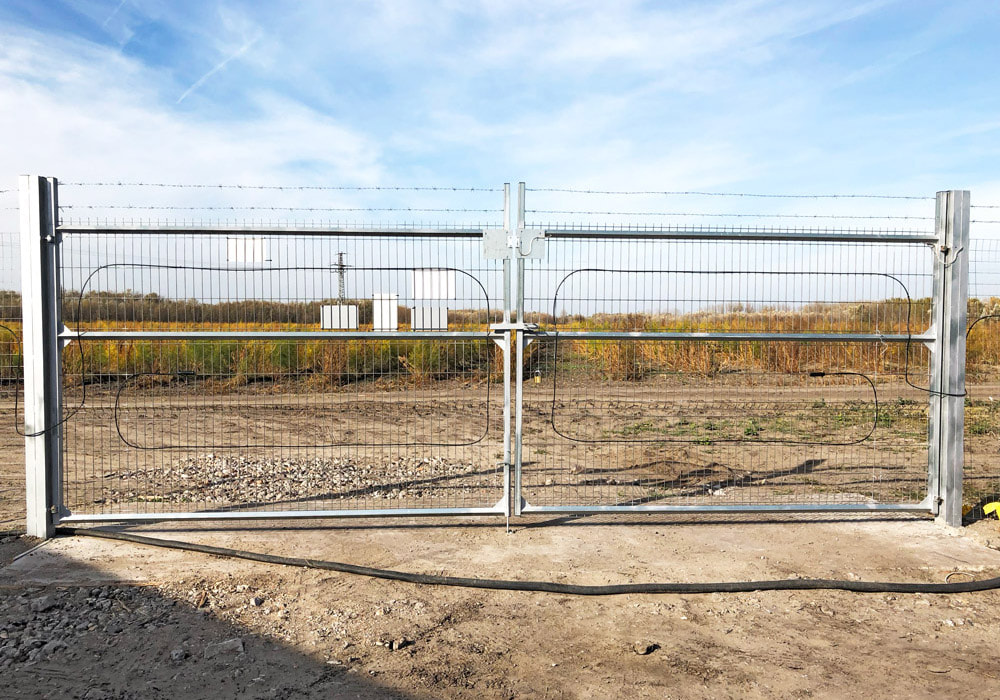 New construction of security technology on solar park: The sensor cable is installed on the gate.